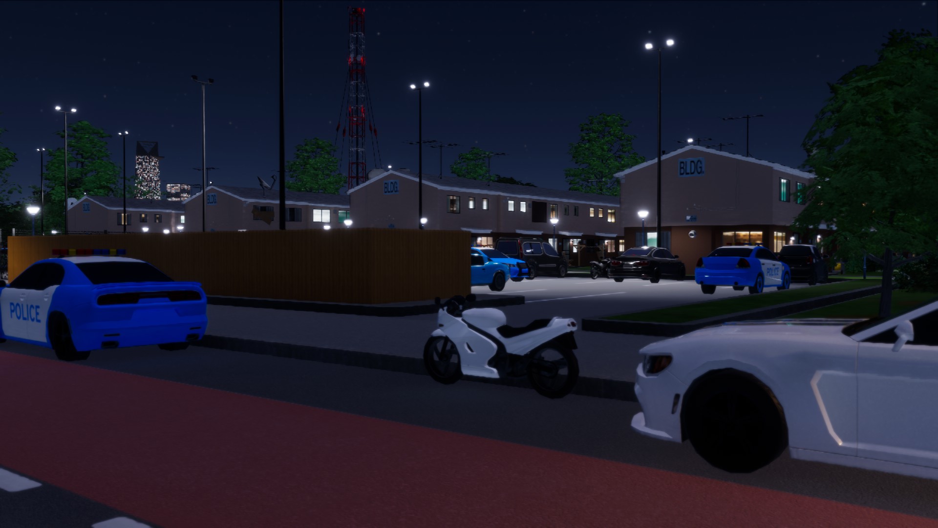 View of the 4th Street complex and police vehicles from the main road at night.