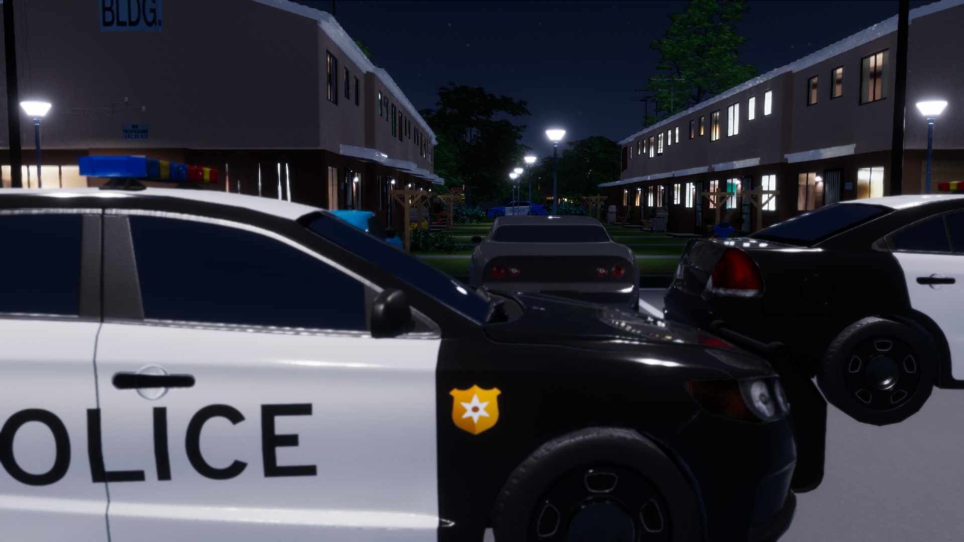 Police vehicles in the parking lot of the 4th Street residential complex at night.